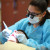 Dental hygiene student cleaning a patient's teeth.